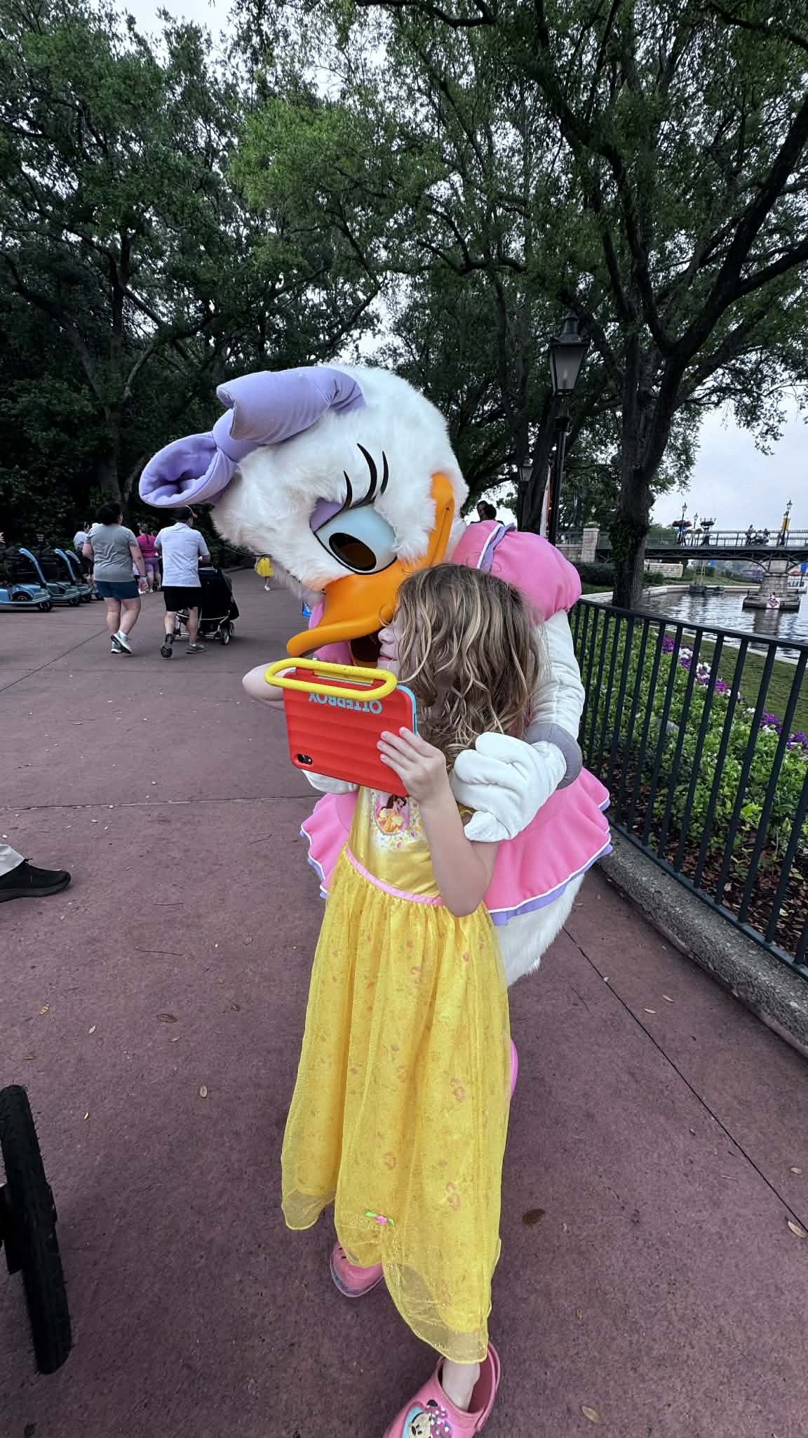 Little girl in a Belle dress hugging Daisy Duck at Epcot